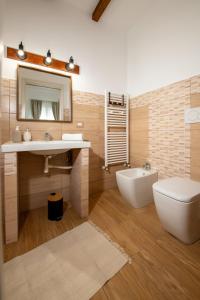 a bathroom with a sink and a toilet and a mirror at Agata's House in Viagrande
