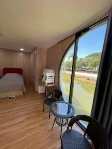 a bedroom with a bed and a table and chairs at The Lakefront Collective in Buriram, Thailand in Ban Nong Muang