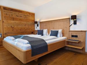 un letto grande in una stanza con pareti di legno di Ferienhaus Veider a Obertilliach
