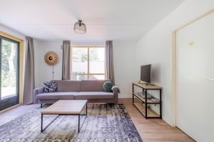 a living room with a couch and a tv at 6 - Persoons Forest 151 Bungalow in Ewijk
