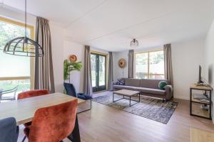 a living room with a table and a couch at 6 - Persoons Forest 151 Bungalow in Ewijk