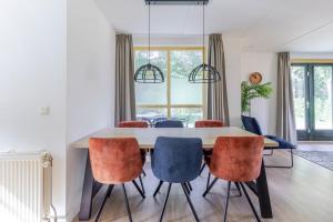a dining room with a table and chairs at 6 - Persoons Forest 151 Bungalow in Ewijk +33 photos