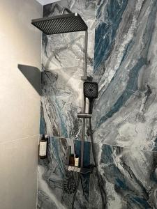 a shower in a bathroom with a marble wall at KNIGHT RESORT Villa & Rooms in Voluntari +24 photos