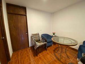 a room with a glass table and chairs and a door at La Casona - Hospedaje Campestre in El Carmen