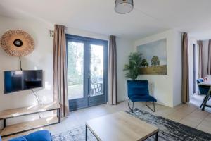 a living room with a blue chair and a sliding glass door at 6 - Persoons Forest 185 Bungalow in Ewijk