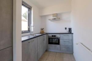 a kitchen with stainless steel appliances and a window at 6 - Persoons Forest 185 Bungalow in Ewijk +24 photos