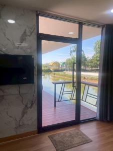 a sliding glass door with a view of a river at The Lakefront Collective in Buriram, Thailand in Ban Nong Muang