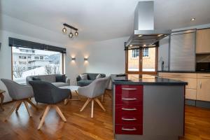 a kitchen with a counter with chairs and a table at Mazot Ferienhaus Kleinwalsertal in Riezlern