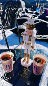 een beeldje van een man die naast twee kopjes koffie staat bij Donovaly Apartman Galileo in Donovaly