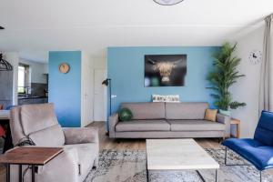 a living room with blue walls and a couch and chairs at 6 - Persoons Forest 193 Bungalow in Ewijk