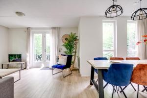 a living room with a table and blue chairs at 6 - Persoons Forest 209 Bungalow in Ewijk