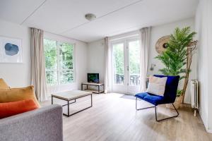 a living room with a couch and a blue chair at 6 - Persoons Forest 209 Bungalow in Ewijk