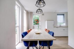 a dining room with a wooden table and blue chairs at 6 - Persoons Forest 209 Bungalow in Ewijk +43 photos