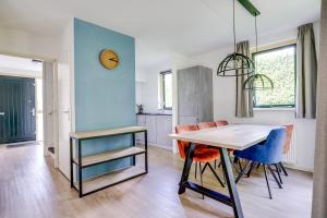 a kitchen and dining room with a table and chairs at 6 - Persoons Forest 231 Bungalow in Ewijk +33 photos