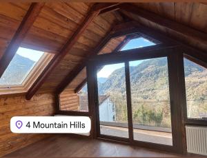 een kamer met een groot raam met uitzicht op de bergen bij 4 MOUNTAIN HILLS in Méga Khoríon +10 foto's