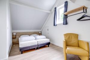 a bedroom with a bed and a chair and a window at 6 - Persons Forest 287 Bungalow in Ewijk