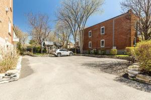 a car parked in front of a brick building at Appartements Saint-Alexandre in Longueuil