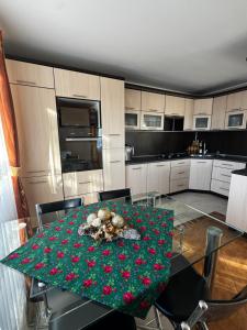 a kitchen with a table with red flowers on it at Spokój u Zosi in Stare Bystre +25 photos