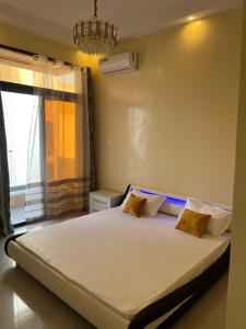 una camera da letto con un letto grande con una finestra di Residence Ndeye Ngouye a Dakar Altre 41 foto