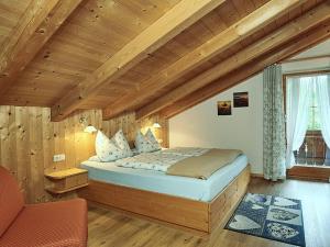 a bedroom with a large bed in a wooden room at Landhaus Eschenbach in Schönau am Königssee