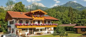 a house with a balcony with flowers on it at Landhaus Eschenbach in Schönau am Königssee
