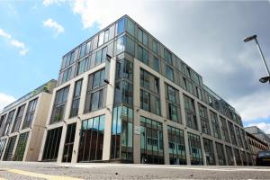 ein Bürogebäude mit Glasfenstern auf einer Straße in der Unterkunft The Viva Apartments 2BD Luxe Garden in Birmingham