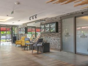 una sala d'attesa con sedie gialle e un muro di mattoni di Laren Sea Side Hotel Spa a Antalya (Adalia)