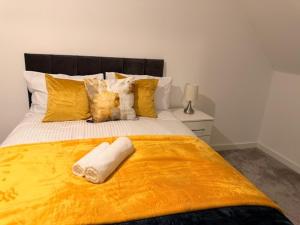 a bedroom with a large bed with yellow sheets and pillows at Pear Barn Haven in Wisbech Saint Mary