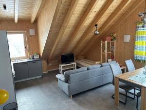 een woonkamer met een bank en een tafel bij Holzliebe mit Donaublick in Kaisheim