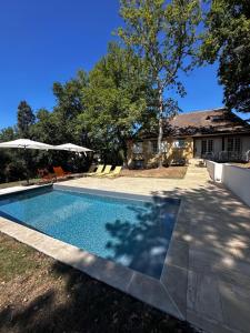 a swimming pool in the yard of a house at LES HAUTS DE TREMOLAT in Trémolat