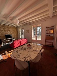 a living room with a table and a couch at LES HAUTS DE TREMOLAT in Trémolat