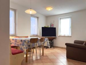 un soggiorno con un tavolo e una televisione di Appartamenti LITEGOSA casa vacanza 2 a Panchia