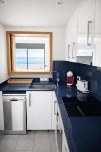 een keuken met een blauw aanrecht en een raam bij Apartamento Califato 5 in Mojácar