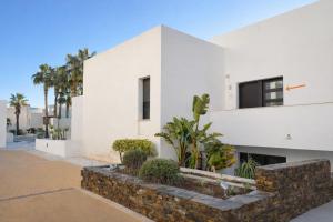een wit huis met een stenen steunmuur bij Apartamento Califato 5 in Mojácar