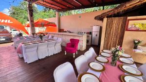 a group of tables and chairs with white tables and pink chairs at Hotel Villa Chucum-Tikuch in Tikuch