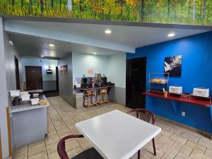 een restaurant met een witte tafel en een toonbank bij Bay Inn in Tawas City