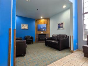 een wachtkamer met banken en een flatscreen-tv bij Bay Inn in Tawas City