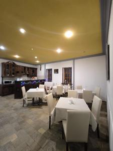 a dining room with white tables and white chairs at Diuma 5 Guest house in Tbilisi City