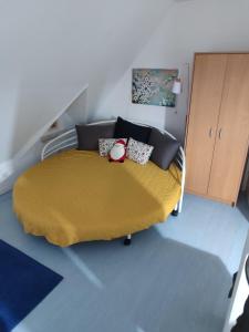 a bedroom with a bed with a yellow blanket at Petra Kuća Apartmani Studio Divčibare Петра Кућа Апартмани Студио Дивчибаре in Divčibare