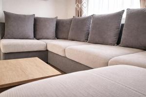 a couch with grey cushions in a living room at Chez Achille in Marcilly-sur-Eure