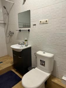 a bathroom with a toilet and a sink and a mirror at SUNNY holidays in Liepāja +18 photos