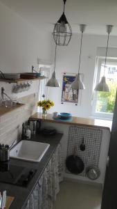 a kitchen with a sink and a counter with pendant lights at Vracar Superb Apartment in Belgrade