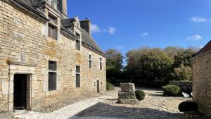 an old brick building with a door and a courtyard at Manoir de Kerenneur in Plourin