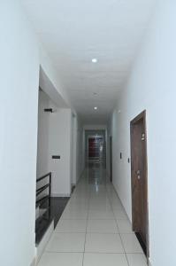 a hallway with white walls and a wooden door at Bhagyashree hotel & restuarant osian in Osiān