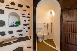 ein Badezimmer mit Toilette und einer mit Kühen verzierten Wand in der Unterkunft Casa Milos Windmill Alonissos in Alonnisos Altstadt