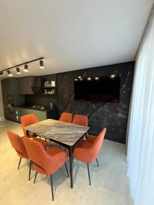 een eetkamer met een tafel en oranje stoelen bij Майя in Mykulychyn
