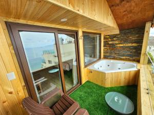 a room with a tub and chairs and a window at Al Mar Cabañas in Viña del Mar
