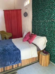 a bedroom with a bed with red pillows on it at Bush Baby Compound in Gunjur