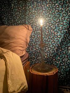a candle on a table next to a bed at Bush Baby Compound in Gunjur +2 photos