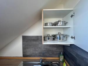 a kitchen with pots and pans on a shelf at Tiny Studiowohnung Bahnhofstrasse 20 in Netzschkau +2 photos